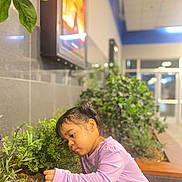 Victoria joined the competition — help win amazing prizes! child, girl, plant, greenery, indoor, garden, curious, lavender_shirt, bench, hair, young, nature, foliage, person, portrait, casual_clothing, daylight, environment, exploring, cute