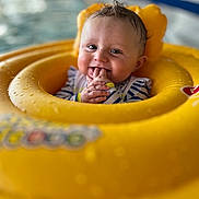 Kaïzen a rejoint le concours — aidez-le/la à gagner de superbes lots ! baby, blue_striped_clothing, chewing_fingers, child, closeup, cute, face, hands, happy, indoor, infant, inflatable, playful, pool, portrait, sitting, smiling, water, wet_hair, yellow_float