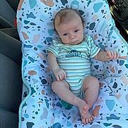 Steven is registered to the contest to win money with this photo: baby, infant, baby_seat, car_interior, onesie, striped_clothing, patterned_fabric, child, cute, person, sitting, blue, white, green, pink, head, feet, arms, face, expression