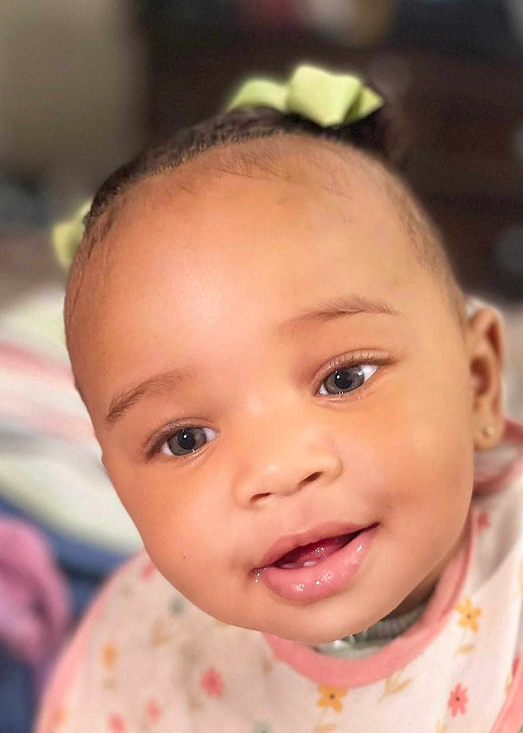 Beyon joined the competition — help win amazing prizes! baby, close_up, face, smile, child, infant, cute, young, portrait, eyes, apparel, bib, hair_bow, skin, cheeks, mouth, expression, adorable, person, indoors