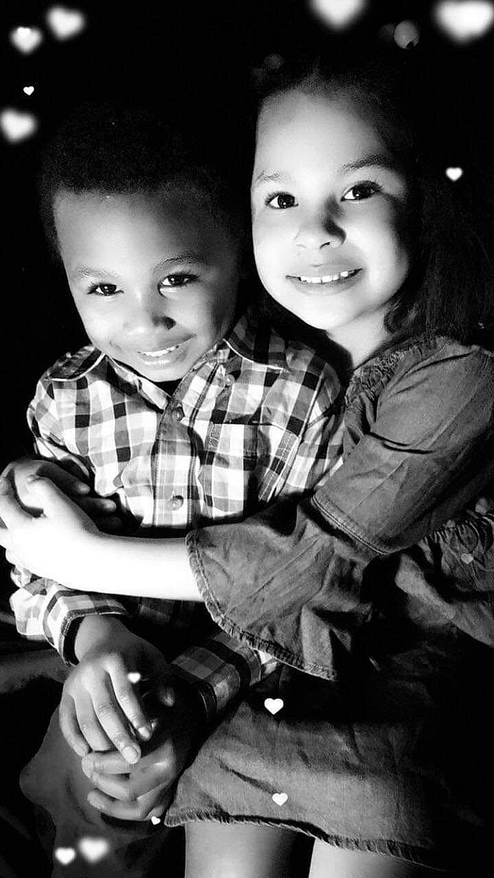 Noella is registered to the contest to win money with this photo: black_and_white, cheek, child, family, gesture, hug, interaction, joy, monochrome, monochrome_photography, people, person, photograph, photography, plaid, sibling, sitting, smile, stock_photography, style