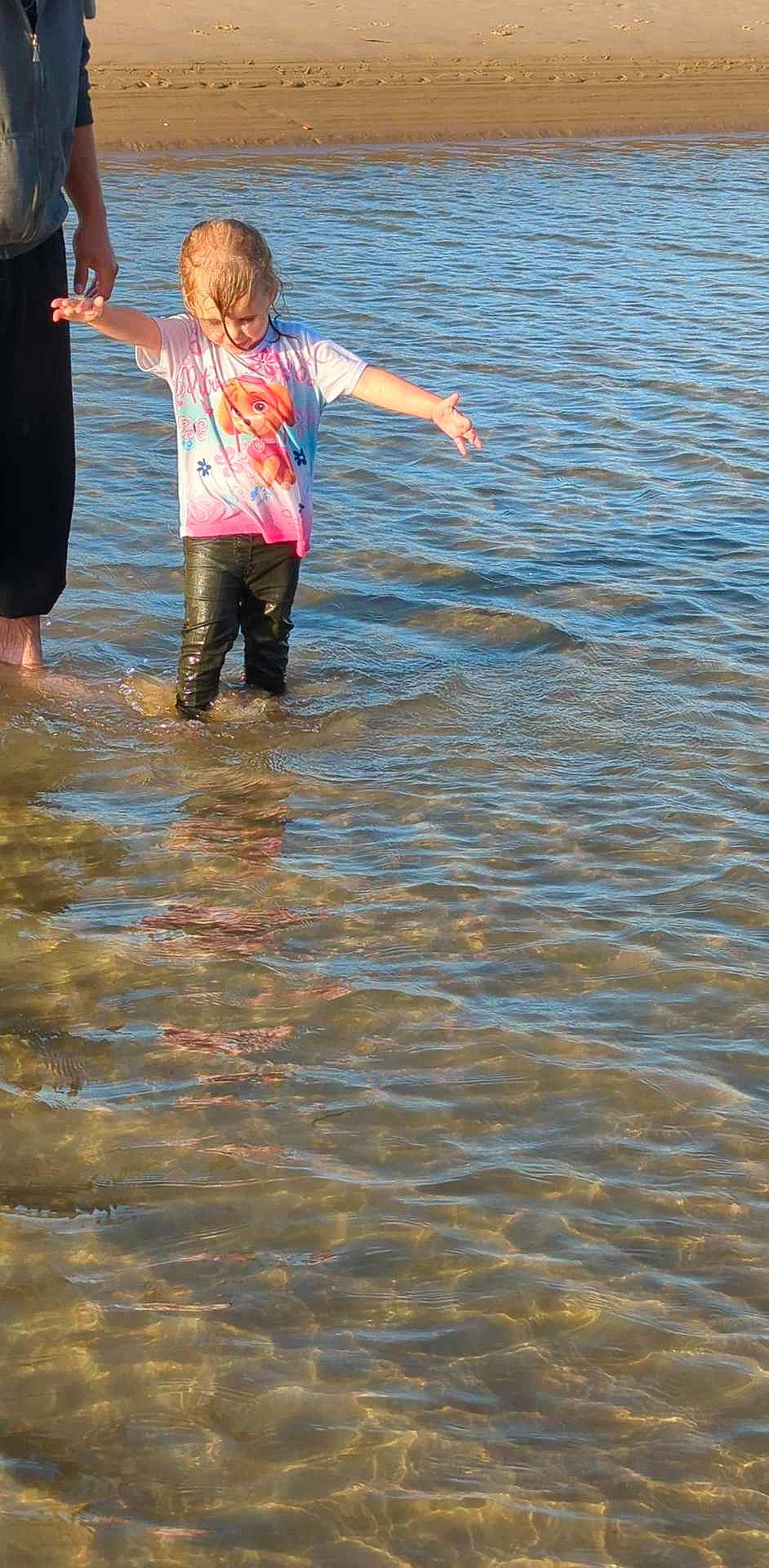 Leïla a rejoint le concours — aidez-le/la à gagner de superbes lots ! barefoot, beach, body_of_water, child, fun, gesture, happy, lake, leisure, ocean, people_in_nature, people_on_beach, person, play, recreation, shorts, t_shirt, toddler, water, wave