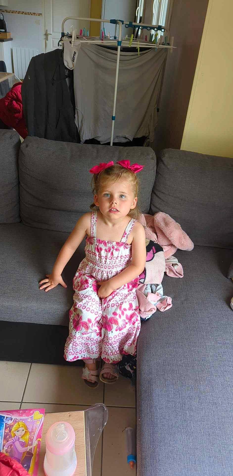 Leïla a rejoint le concours — aidez-le/la à gagner de superbes lots ! baby_toddler_clothing, child, comfort, couch, dress, eye, face, flooring, fun, happy, head, human_body, human_leg, leisure, living_room, magenta, person, pink, sock, thigh