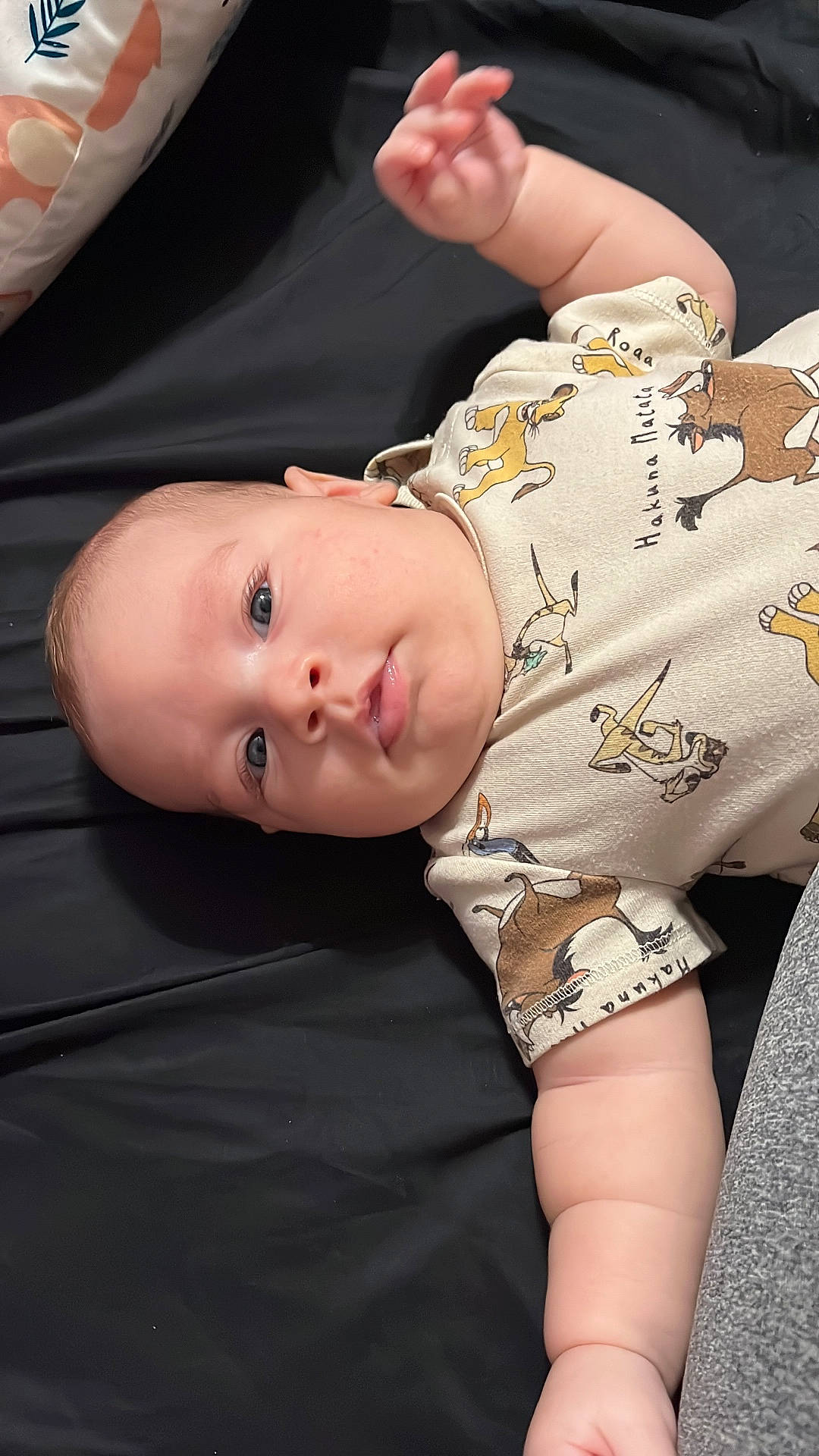 Oliver Samuel is registered to the contest to win money with this photo: baby, blue_eyes, cartoon_characters, casual_clothing, child, chubby_cheeks, close_up, cute, fabric, hand, indoor, infant, lion_king, lying_down, newborn, onesie, pillow, portrait, sleeping_surface, soft_skin