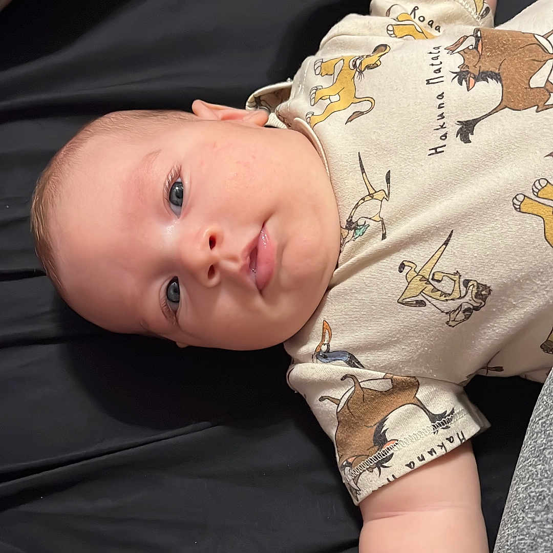 Oliver Samuel joined the competition — help win amazing prizes! baby, blue_eyes, cartoon_characters, casual_clothing, child, chubby_cheeks, close_up, cute, fabric, hand, indoor, infant, lion_king, lying_down, newborn, onesie, pillow, portrait, sleeping_surface, soft_skin