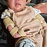 baby, child, infant, portrait, cowboy_hat, straw_hat, sitting, indoors, person, face, wide_eyed, clothing, overalls, shirt, sock, floral_pattern, adult_arm, chair, close_up, funny_expression
