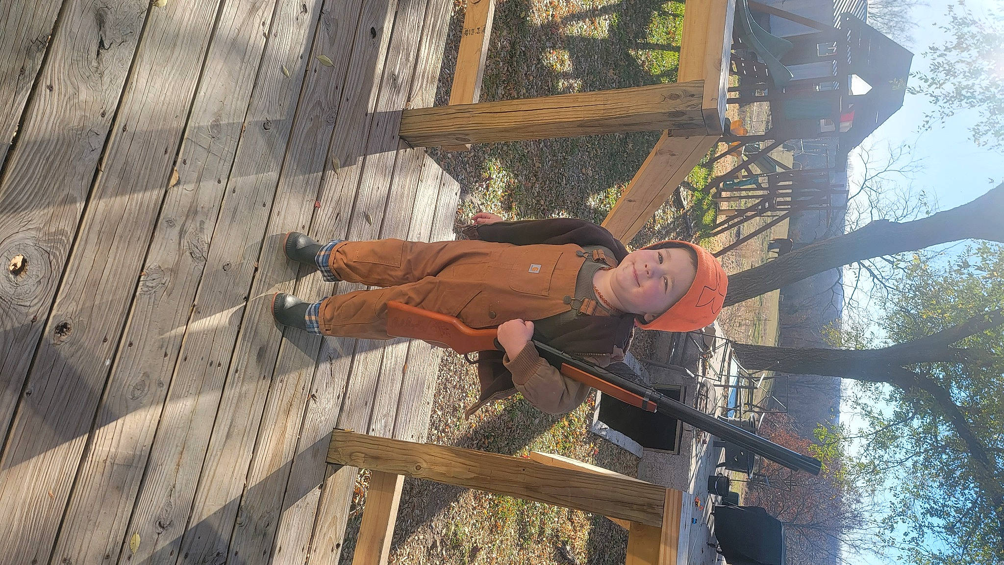 Jake is registered to the contest to win money with this photo: flooring, fun, hardwood, hat, headwear, joy, leisure, lumber, person, plank, shorts, t_shirt, tree, walking_shoe, water, wood, wood_stain