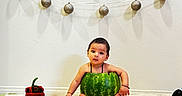 Aadvik joined the competition — help win amazing prizes! birthday, cake, celebration, child, colorful, cute, decorations, festive, floor_mat, food, fruit, indoor, ornaments, party, sitting, string_lights, toddler, wall, watermelon, young_child