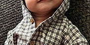 Kamillo is registered to the contest to win money with this photo: baby, infant, child, hooded_clothing, checkered_pattern, smile, face, hair, buttoned_shirt, fabric, texture, portrait, cute, lying_down, indoors, skin, young, person, eyes, cozy