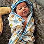 baby, child, towel, hooded_towel, paw_print, carpet, soft_toy, plush, blanket, clothing, cute, infant, smiling, indoors, floor, person, portrait, wrapped, cozy, babywear