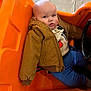 Blaine joined the competition — help win amazing prizes! baby, child, jacket, orange, toy_car, indoor, floor, clothing, person, seat, expression, blue_pants, casual, play, cute, head, face, young, leisure, fun