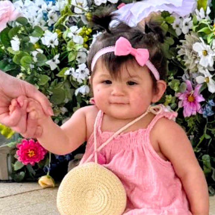 Symphony joined the competition — help win amazing prizes! baby, barefoot, bodypart, clothing, dress, face, finger, flower, flowerarrangement, flowerbouquet, geranium, hand, hat, head, person, petal, photography, plant, portrait, pottedplant