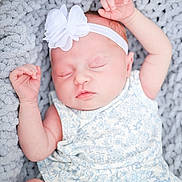 Delilah joined the competition — help win amazing prizes! baby, infant, sleeping, headband, flower, blanket, knit, soft, cute, peaceful, child, newborn, clothing, blue_flower_pattern, skin, face, arms, closed_eyes, resting, portrait