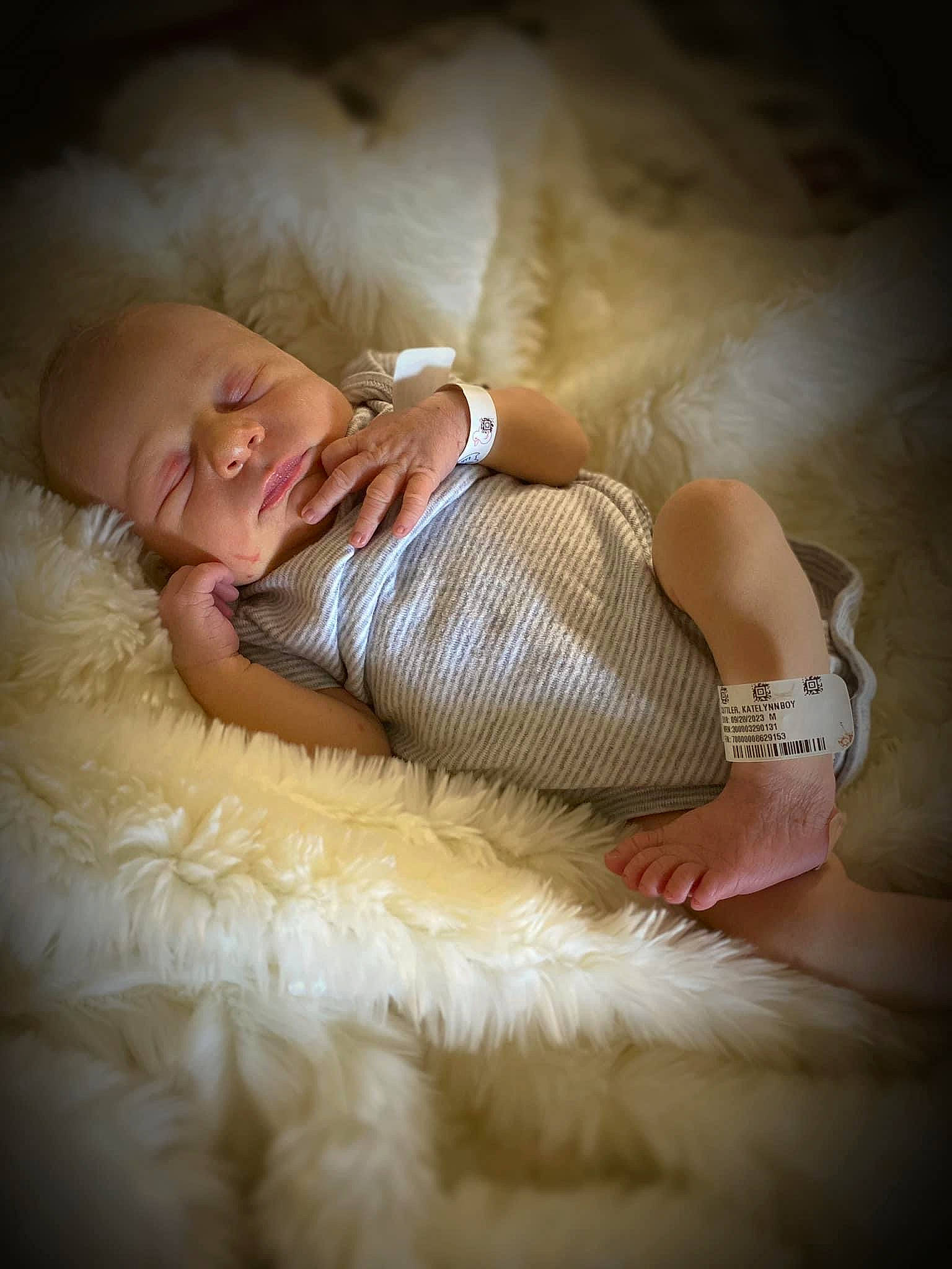 Levi is registered to the contest to win money with this photo: abdomen, arm, baby, bed, child, comfort, flash_photography, fur, glasses, happy, human_body, human_leg, knee, linens, person, sitting, skin, textile, thigh, toddler