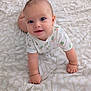 baby, infant, crawling, blue_eyes, floral_onesie, cute, child, skin, face, smile, blanket, pattern, soft, indoors, young, head, hands, fingers, floor, expression