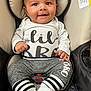 baby, smiling, infant, car_seat, clothing, white_shirt, gray_pants, socks, baby_boy, happy, cute, child, face, portrait, seated, indoor, baby_fashion, baby_accessory, car_safety, closeup