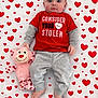 baby, infant, child, blue_eyes, red_shirt, grey_pants, plush_toy, stuffed_monkey, heart_pattern, heart_blanket, lying_down, top_view, portrait, cute, adorable, fabric, bare_feet, hands, clothing, gaze_direct