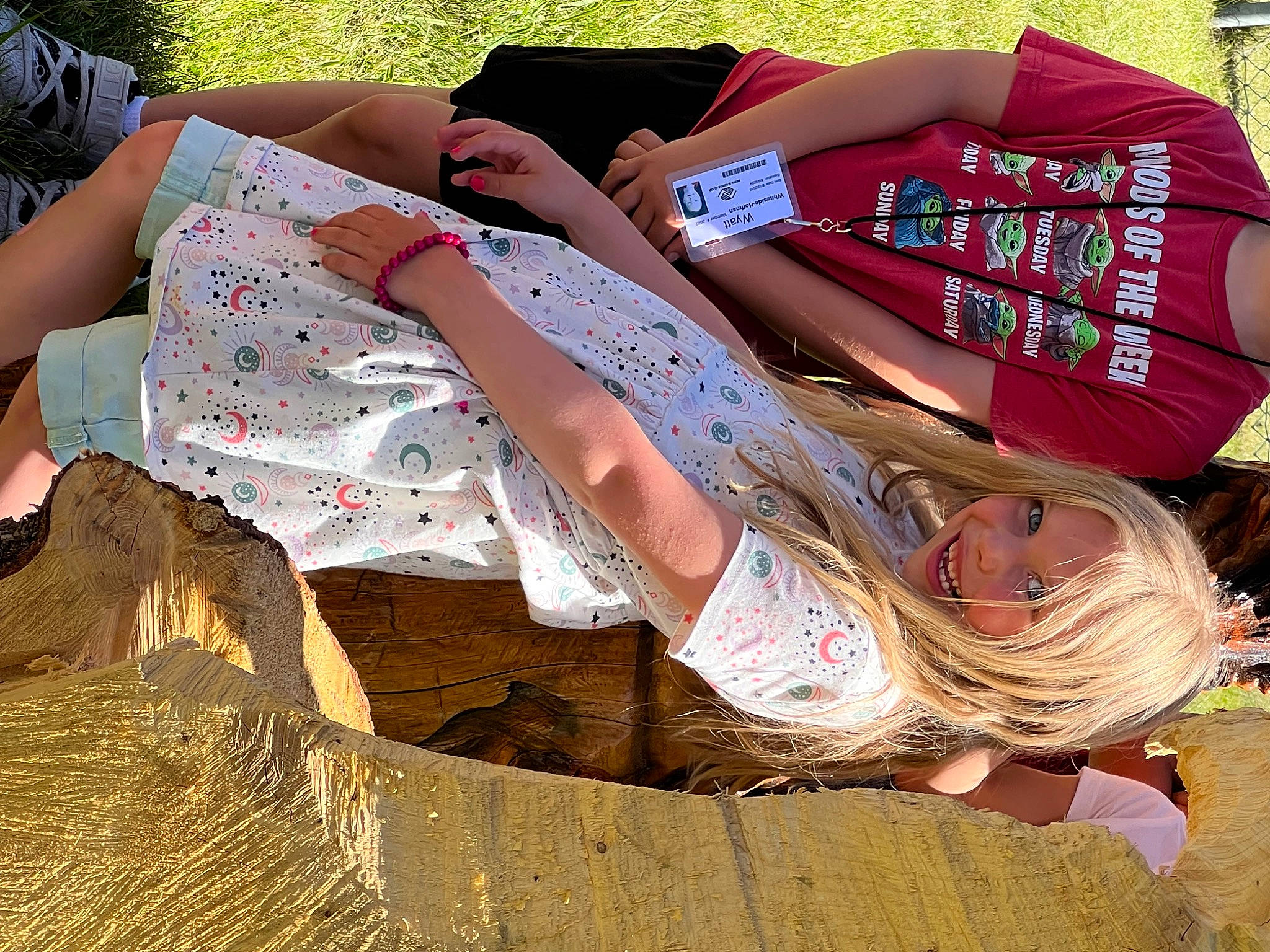 Leora is registered to the contest to win money with this photo: brown_hair, cool, eyewear, fashion_design, foot, grass, happy, human_leg, joint, knee, leisure, long_hair, pattern, people_in_nature, person, pink, sitting, thigh, trunk, waist