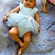 Liya is registered to the contest to win money with this photo: baby, child, tutu, headband, bow, blanket, plush, pillow, cartoon, dog, hairbrush, glasses, pen, clothing, cute, infant, smiling, lying_down, soft_texture, indoors