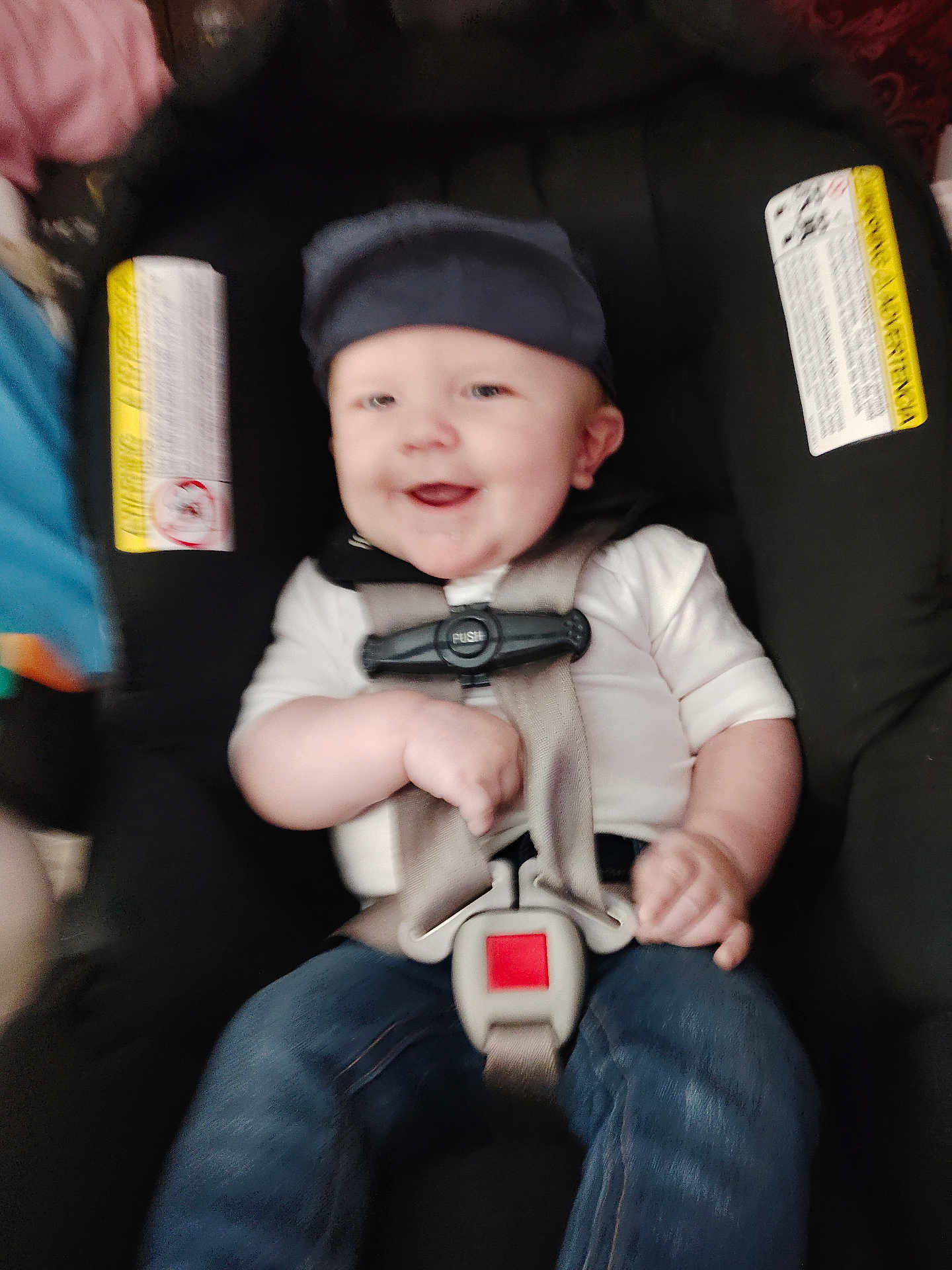 Ashen is registered to the contest to win money with this photo: baby, child, car_seat, smiling, cap, straps, clothing, jeans, happy, infant, seatbelt, person, cute, young, sitting, indoor, safety, child_safety, headwear, casual