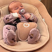 Alma a rejoint le concours — aidez-le/la à gagner de superbes lots ! baby, infant, pacifier, baby_seat, onesie, cushion, plush_toys, wooden_cabinet, indoor, sleepy, cute, child, person, soft_fabric, relaxing, home, comfort, clothing, face, small_hands