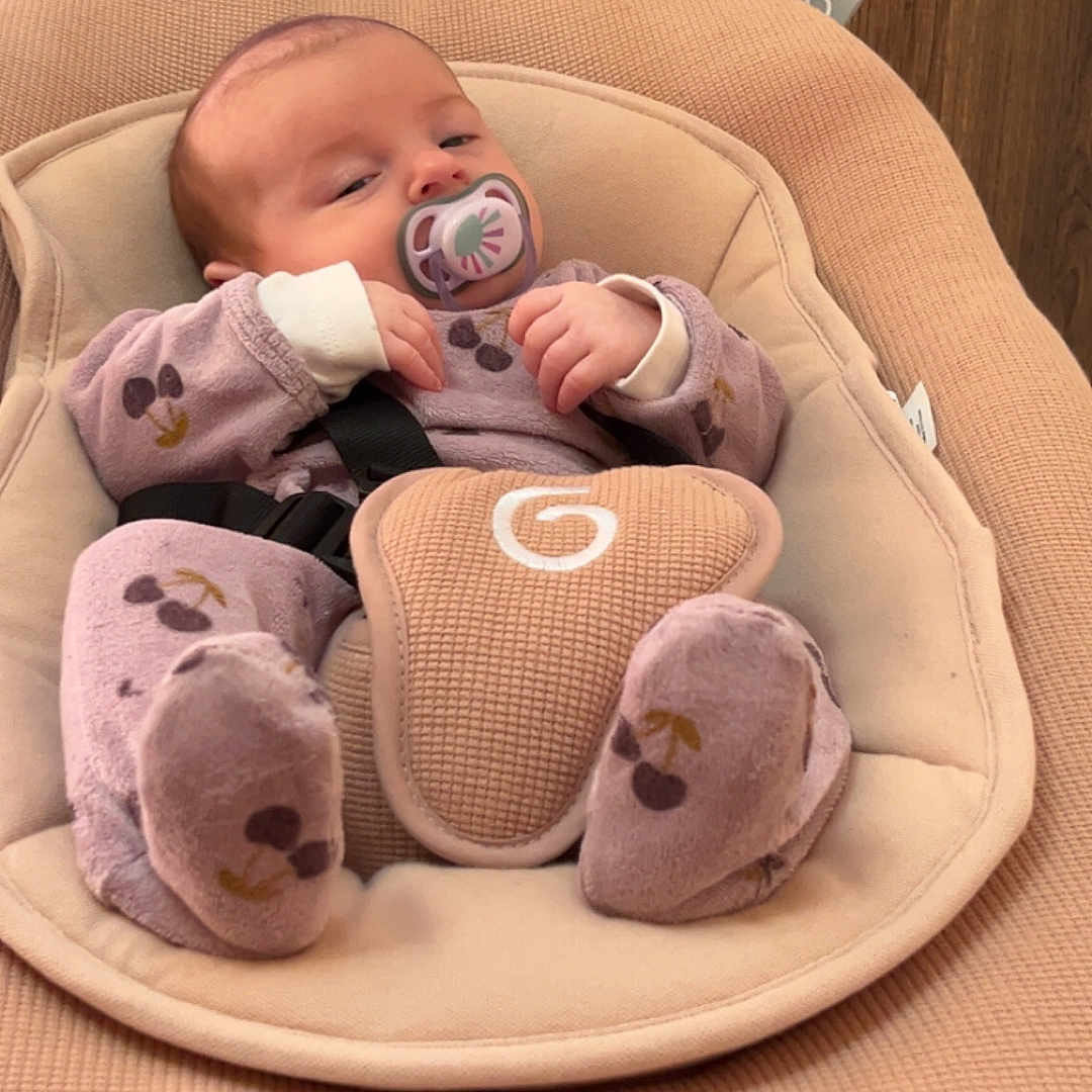 Alma a rejoint le concours — aidez-le/la à gagner de superbes lots ! baby, baby_seat, child, clothing, comfort, cushion, cute, face, home, indoor, infant, onesie, pacifier, person, plush_toys, relaxing, sleepy, small_hands, soft_fabric, wooden_cabinet