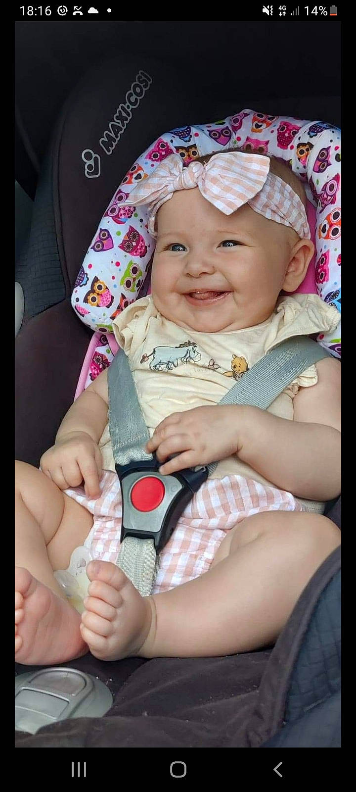 Maisie is registered to the contest to win money with this photo: baby, baby_toddler_clothing, cheek, child, comfort, eye, face, facial_expression, finger, gesture, happy, headwear, joy, lip, mouth, person, pink, product, seat_belt, skin