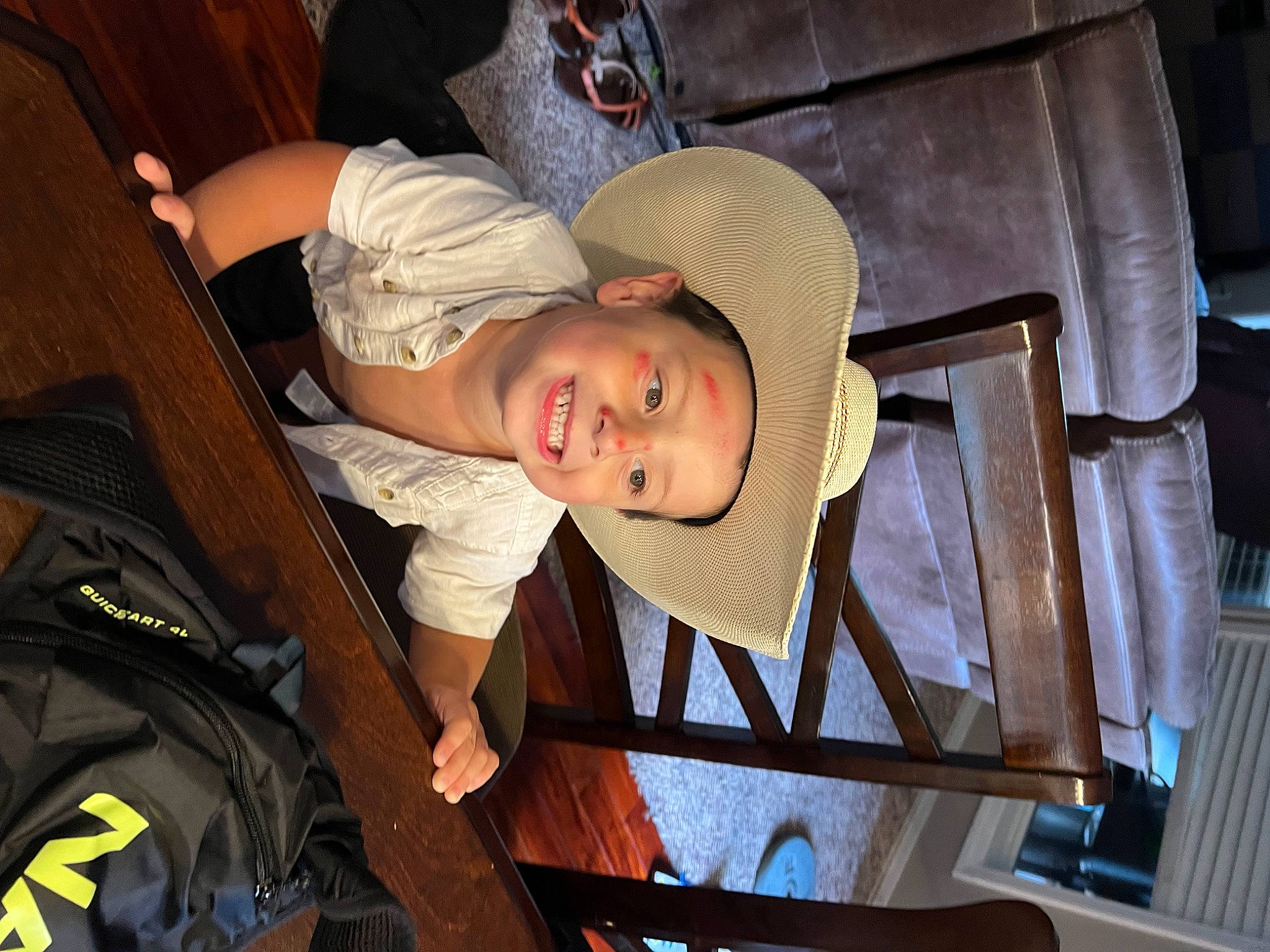Jack is registered to the contest to win money with this photo: baby, baby_carriage, baby_products, baby_toddler_clothing, baseball_cap, cap, chair, child, comfort, fun, hat, joy, person, room, smile, sun_hat, t_shirt, toddler, wood