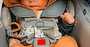Nolan is registered to the contest to win money with this photo: baby, infant, sleeping, car_seat, hooded_outfit, orange_clothing, harness, seatbelt, vehicle_interior, portrait, close_up, peaceful, cozy, feet, hands, closed_eyes, gray_car_seat, heart_emojis, child, photography