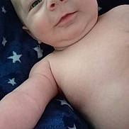 Nolan joined the competition — help win amazing prizes! baby, infant, child, face, smiling, eyes, portrait, lying_down, blanket, stars, navy_blue, indoors, close_up, bare_shoulders, happy, cute, cozy, photograph, head, baby_portrait