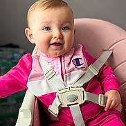 Adele joined the competition — help win amazing prizes! baby, child, pink_clothing, high_chair, smile, face, eyes, earring, seatbelt, indoor, person, happy, infant, cute, portrait, soft_lighting, young_child, jacket, zipper, closeup