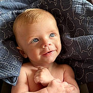 Arthur participe au concours pour gagner de l'argent avec cette photo : baby, blanket, blue_eyes, child, closeup, cozy, cute, expression, face, hands, happy, indoors, infant, portrait, sitting, skin, smiling, soft_light, whale_pattern, young