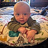 baby, infant, pillow, animal_print, bedroom, dresser, bottle, blanket, curious, child, indoor, person, furniture, cozy, home, soft, cute, portrait, wide_eyes, toddler