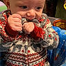 Rowen joined the competition — help win amazing prizes! baby, child, infant, sweater, festive_clothing, chewing, hands, face, head, seat, baby_seat, colorful, blue, red, patterned_clothing, indoor, portrait, cute, expression, lock_screen_overlay