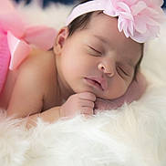 Charlotte is registered to the contest to win money with this photo: baby, newborn, sleeping, headband, pink_flower, fluffy_blanket, soft_texture, closeup, portrait, infant, peaceful, cute, resting, skin, hand, face, indoors, cozy, adorable, child