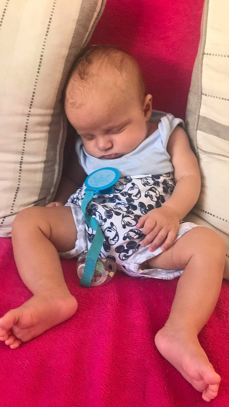 Mathis a rejoint le concours — aidez-le/la à gagner de superbes lots ! arm, baby, baby_toddler_clothing, cheek, comfort, couch, finger, hand, human_body, iris, lap, leg, mammal, mouth, person, pink, shoulder, skin, sleeve, thigh