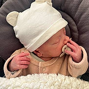 Elijah participe au concours pour gagner de l'argent avec cette photo : baby, newborn, pacifier, hat, bear_ears, blanket, cushion, sleeping, infant, clothing, hand, face, cute, soft, resting, indoors, warm, cozy, child, portrait