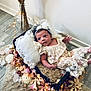 baby, basket, blanket, cozy, cushion, cute, decor, fairy_lights, flower_petals, headband, indoor, infant, lace_clothing, newborn, pampas_grass, portrait, resting, soft_lighting, vase, wooden_floor