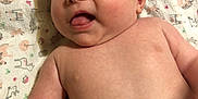 Presley joined the competition — help win amazing prizes! baby, infant, face, tongue, expression, skin, arm, blanket, pattern, laying, cute, child, person, naked_torso, head, mouth, cheek, young, human, soft