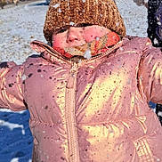 Emilia Springsteen is registered to the contest to win money with this photo: child, snow, winter, coat, hat, scarf, outdoor, cold, play, snowflakes, pink, cute, face, smile, frozen, fun, warm_clothing, daylight, background, snowy_ground