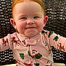 baby, child, red_hair, smile, face, pajamas, christmas_theme, santa, reindeer, chair, woven_chair, happy, cute, portrait, indoors, infant, holiday, seasonal_clothing, person, young_child
