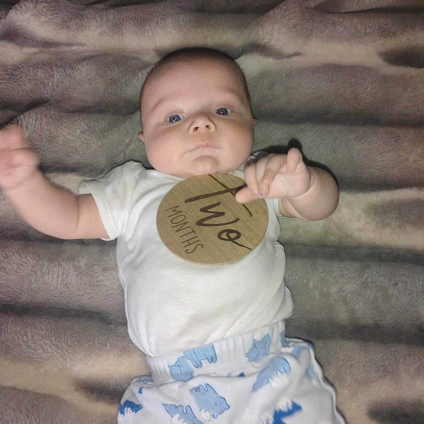 Wrangler is registered to the contest to win money with this photo: baby, blanket, blue, clothing, cute, face, hand, infant, lying_down, newborn, one_person, patterned_pants, plush, portrait, reaching, shirt, soft_texture, two_months, white, young_child