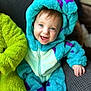 Dougie joined the competition — help win amazing prizes! baby, child, infant, smiling, blue_costume, hooded_onesie, purple_spots, sitting, couch, white_socks, happy, face, eyes, hand, fuzzy_texture, cozy, indoor, portrait, cute, young