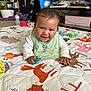 Sienna is registered to the contest to win money with this photo: baby, infant, smiling, pacifier, bib, quilt, animal_print, toy, floor_play, indoor, child, cute, happy, face, hand, home, carpet, clothing, furniture, living_room