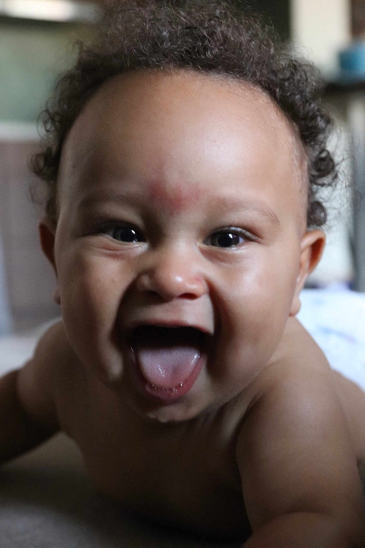 Nayan participe au concours pour gagner de l'argent avec cette photo : baby, child, curly_hair, smiling, tongue_out, close_up, face, skin, happy, infant, mouth_open, indoor, person, young_child, expression, cute, portrait, cheerful, playful, head