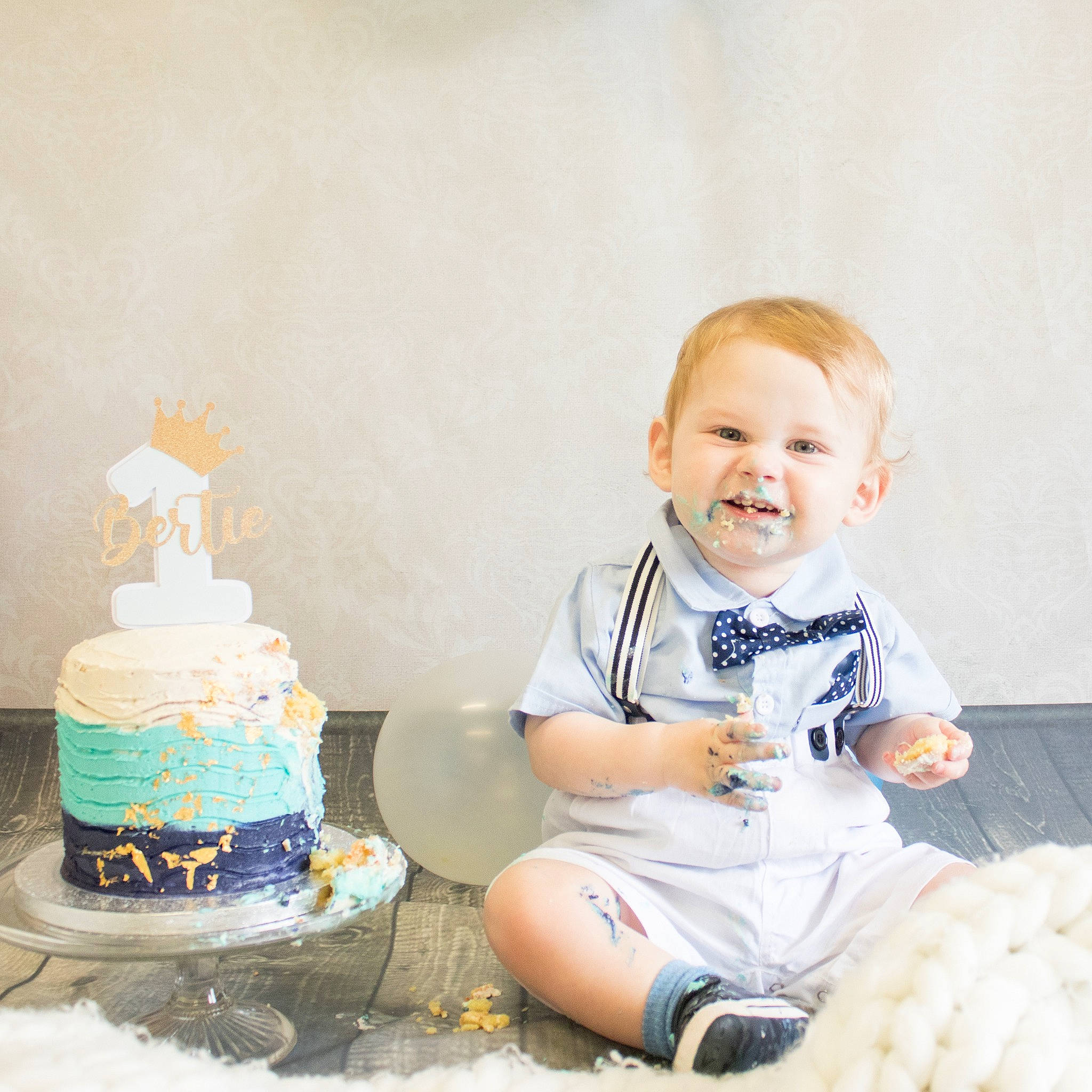 Bertie is registered to the contest to win money with this photo: baby, baby_toddler_clothing, birthday_cake, cake, cake_decorating, cake_decorating_supply, dessert, electric_blue, food, happy, icing, joy, knee, people, person, sleeve, smile, sock, sugar_cake, sugar_paste