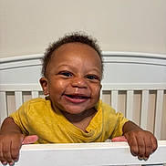 Raheem joined the competition — help win amazing prizes! baby, child, crib, curly_hair, cute, expression, face, furniture, grip, hands, happy, home, indoor, infant, person, portrait, smiling, toddler, yellow_shirt, young_child