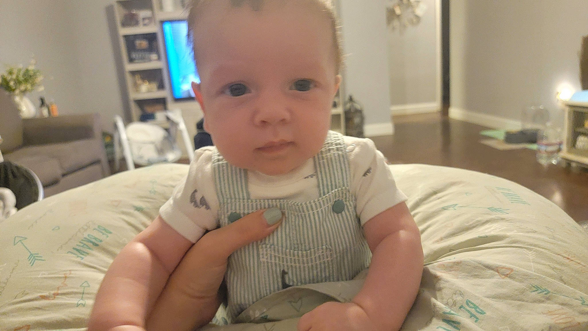 Paxton is registered to the contest to win money with this photo: baby, baby_toddler_clothing, bookcase, cheek, child, chin, comfort, facial_expression, fun, iris, mouth, nose, person, picture_frame, room, shelf, sitting, skin, sleeve, smile