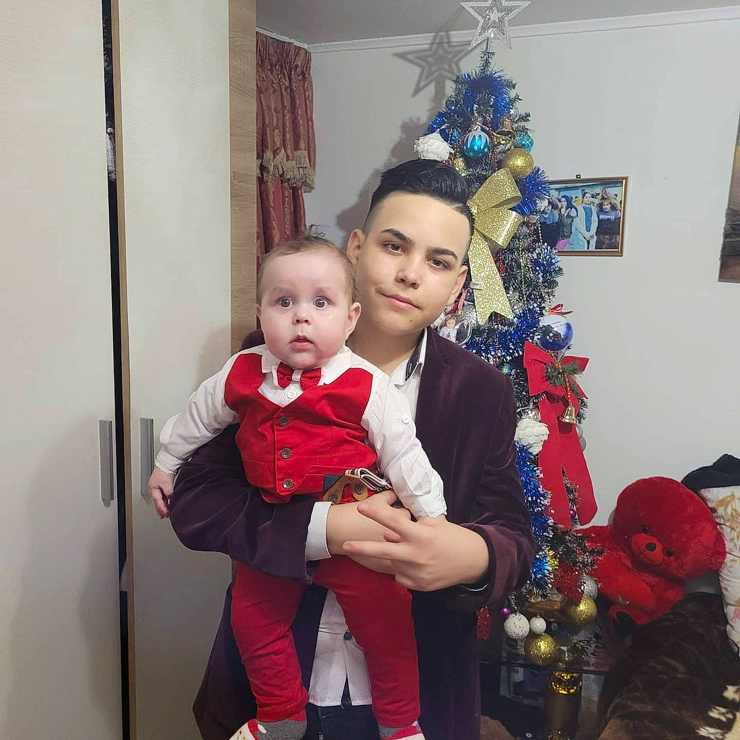 Dominik is registered to the contest to win money with this photo: baby, baby_toddler_clothing, boot, carmine, christmas, christmas_decoration, christmas_eve, christmas_ornament, christmas_tree, holiday, holiday_ornament, interior_design, lap, love, ornament, person, picture_frame, red, sock, surprise