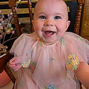 Charlotte joined the competition — help win amazing prizes! baby, child, smiling, pink_dress, embroidery, wooden_chair, happy, portrait, cute, indoor, face, young_child, toddler, sitting, apparel, person, closeup, cute_expression, celebration, adorable